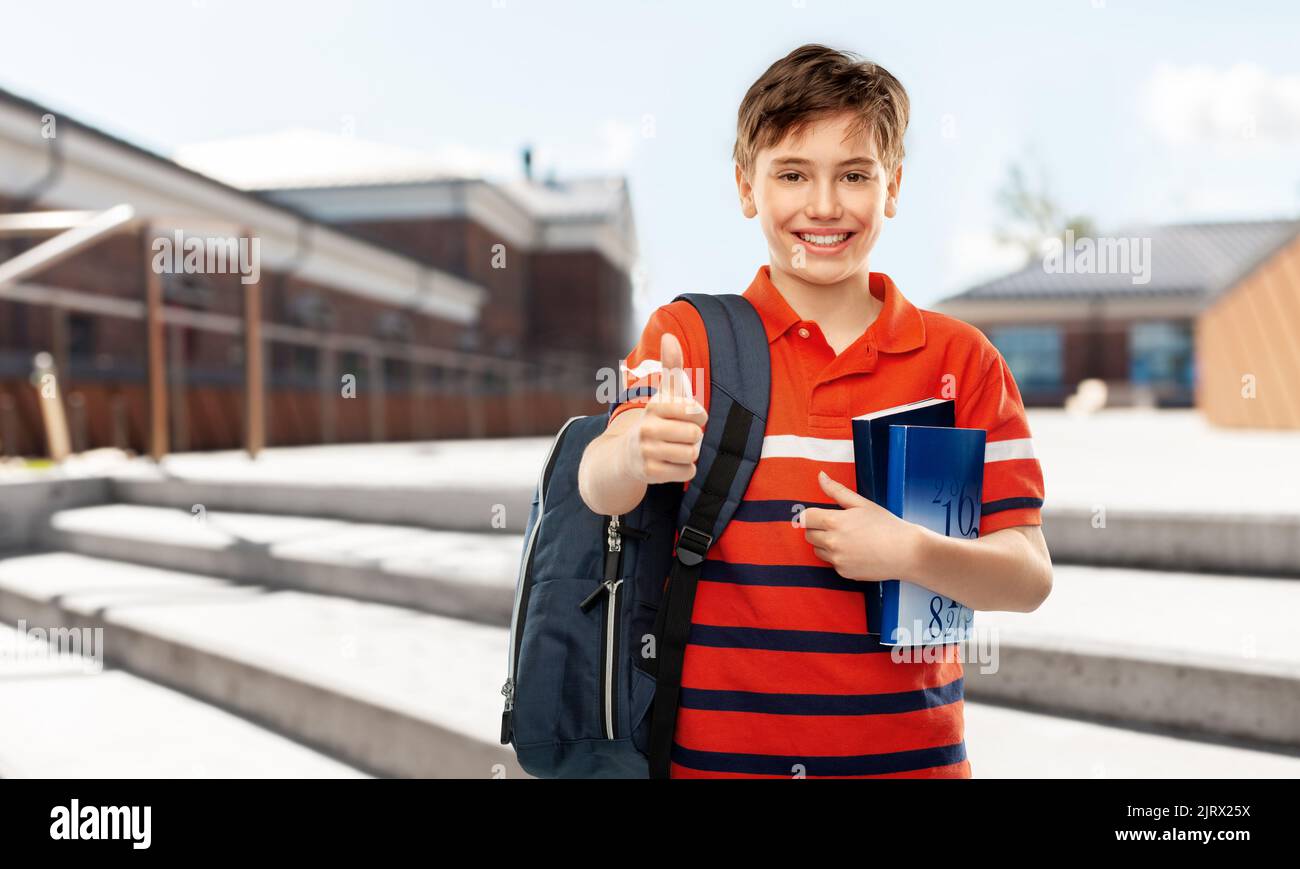student boy with bag and books showing thumbs up Stock Photo - Alamy
