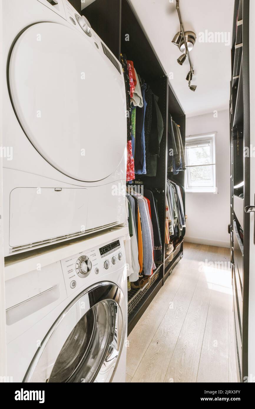 Laundry room interior. Utility room with washing machine, cleaning  equipment, home cleaners, clean wipes, hanging colorful shirts on  clothesline on wh Stock Photo - Alamy