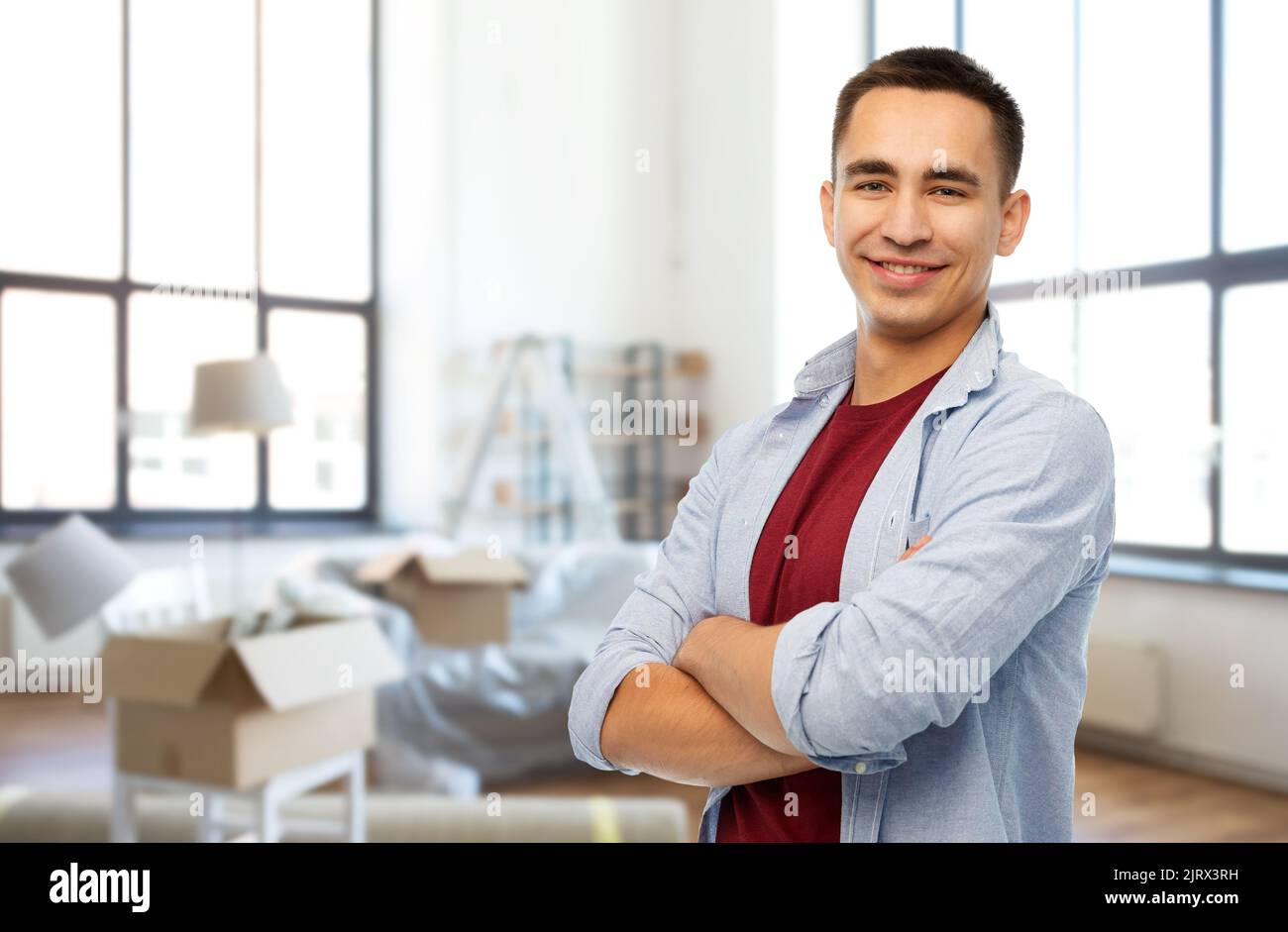 smiling young man over new home background Stock Photo - Alamy