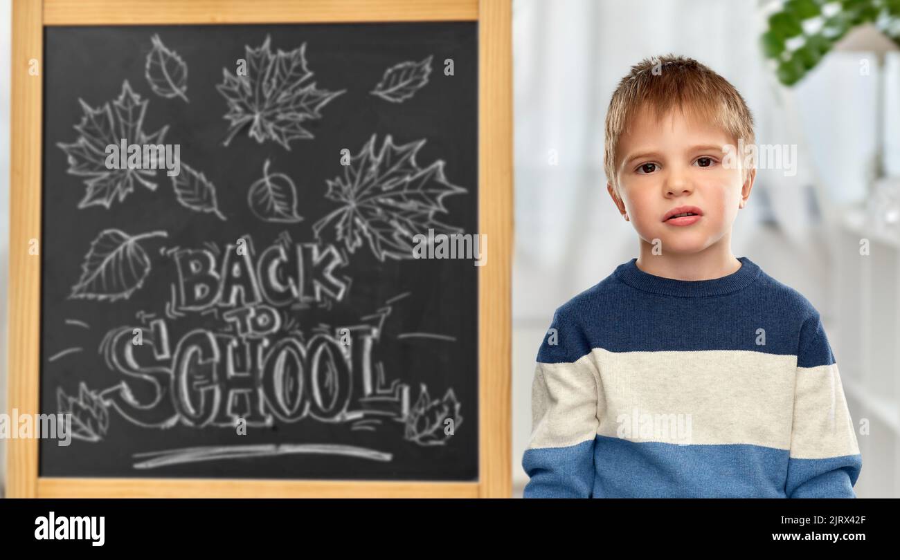 bored little student boy over school blackboard Stock Photo - Alamy