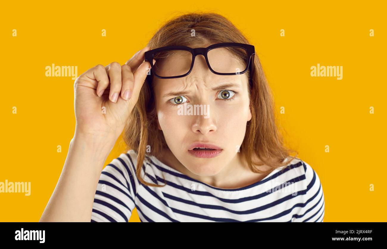 Confused woman looks at you with suspicious, doubtful and incredulous expression on her face. Stock Photo