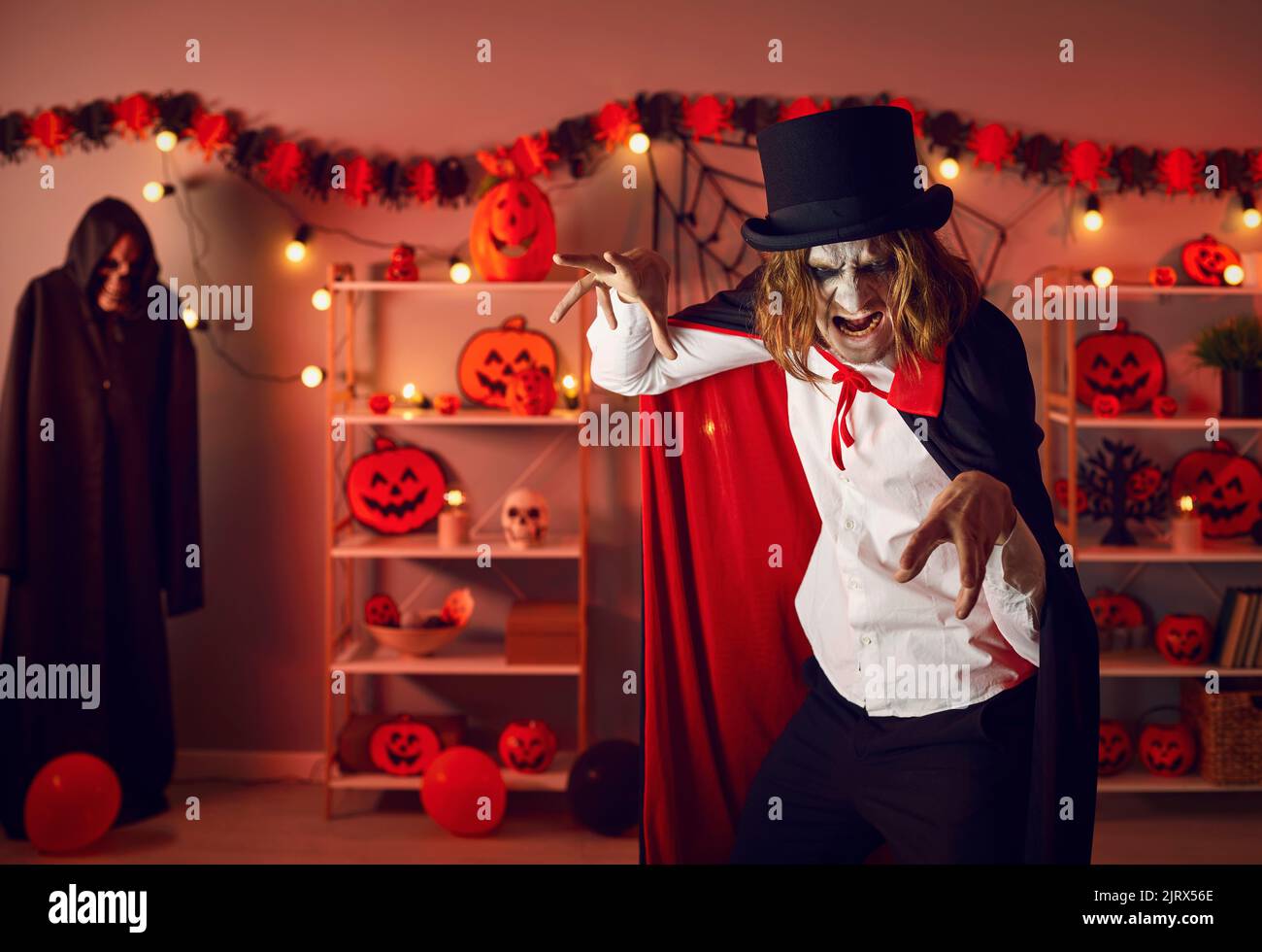 Portrait of an adult man dressed up in a spooky Halloween costume of an evil vampire Stock Photo