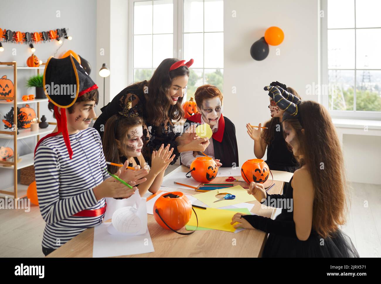 Art and Craft teacher and children in spooky Halloween costumes having ...