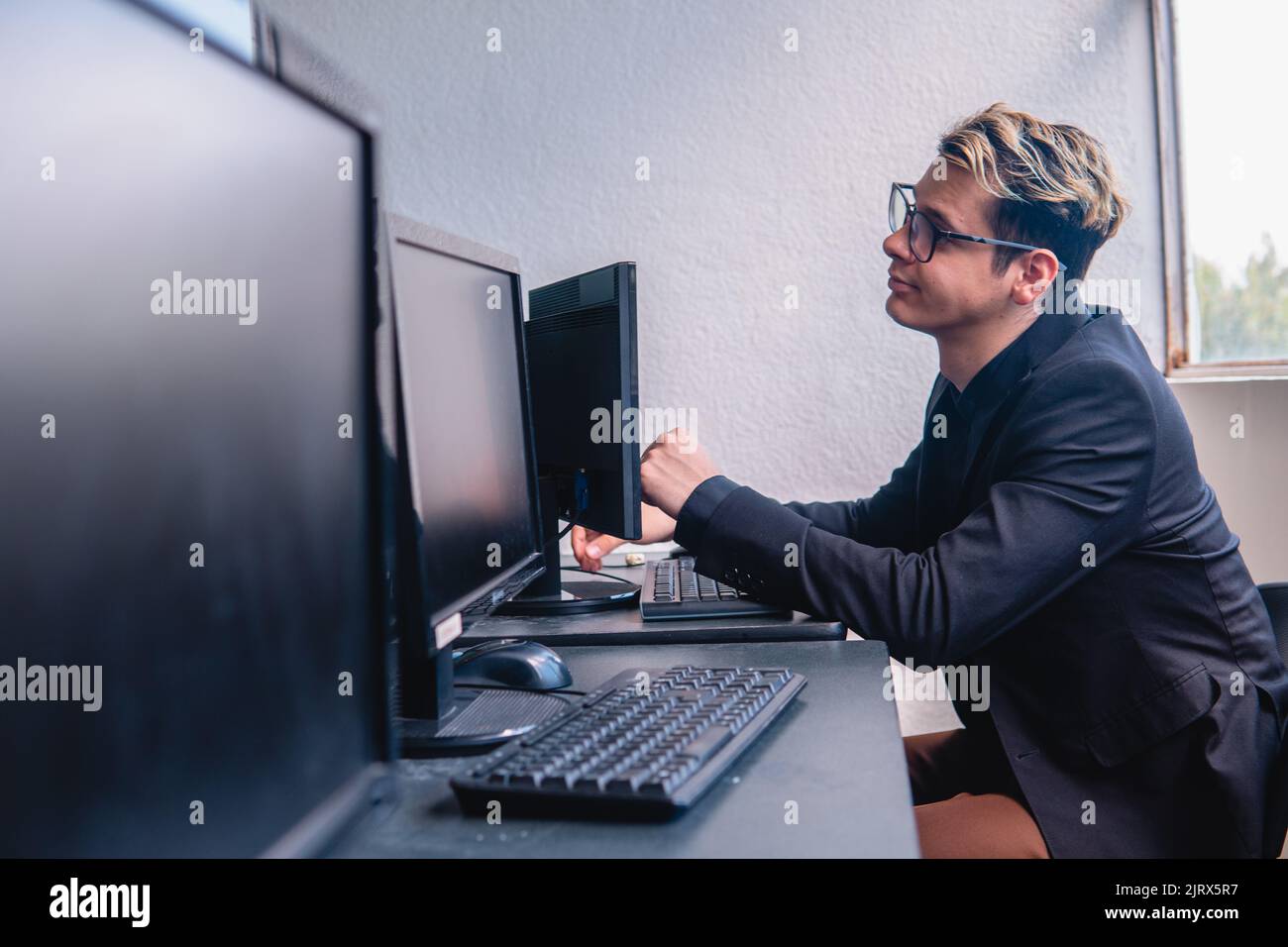 Office worker working hard on his computer. Office full of computers ...