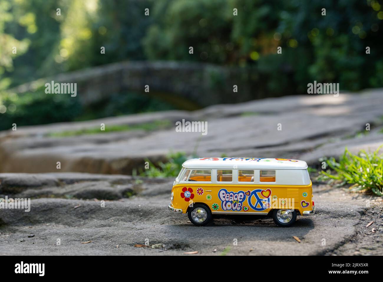 Yellow VW camper van model bus, in a nature scene, on a rock. Stock Photo