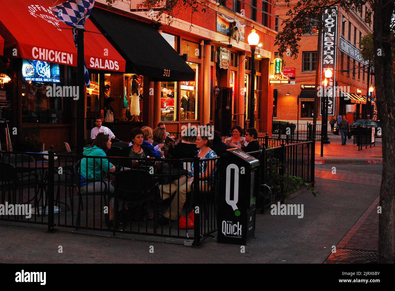 A group of women enjoy a an alfresco dinner at night in a trendy restaurant and cafe in the West End of Dallas Texas Stock Photo