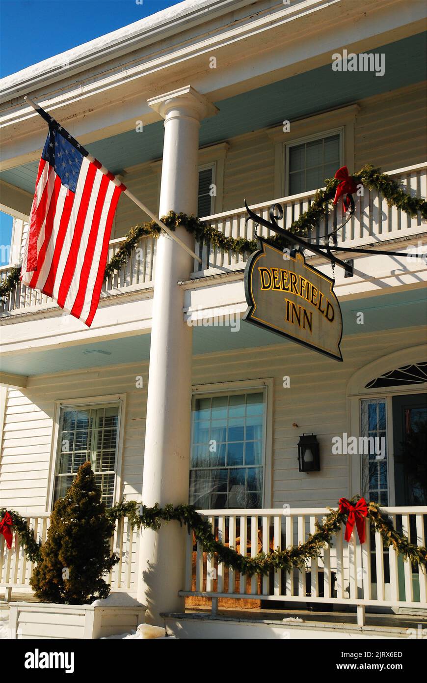 Holly and bows adorn the railing of the porch and balcony of the Deerfield Inn during the Christmas season Stock Photo