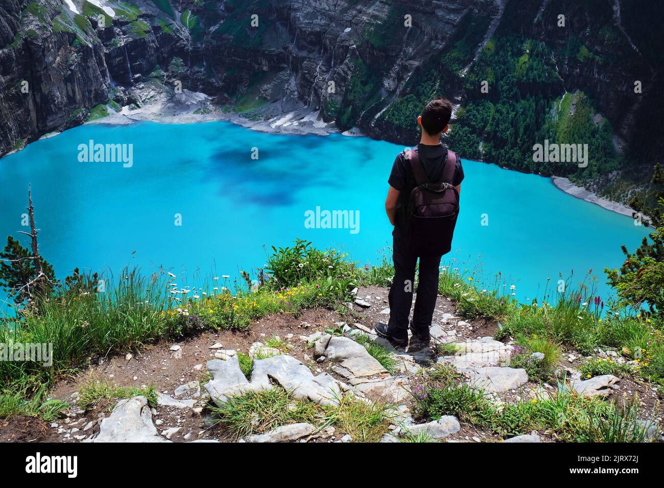 Relaxing on the shore of Oeschinen Lake (Oeschinensee) in  Kandersteg, the Bernese Oberland, Switzerland, part of the UNESCO World Heritage Site Stock Photo