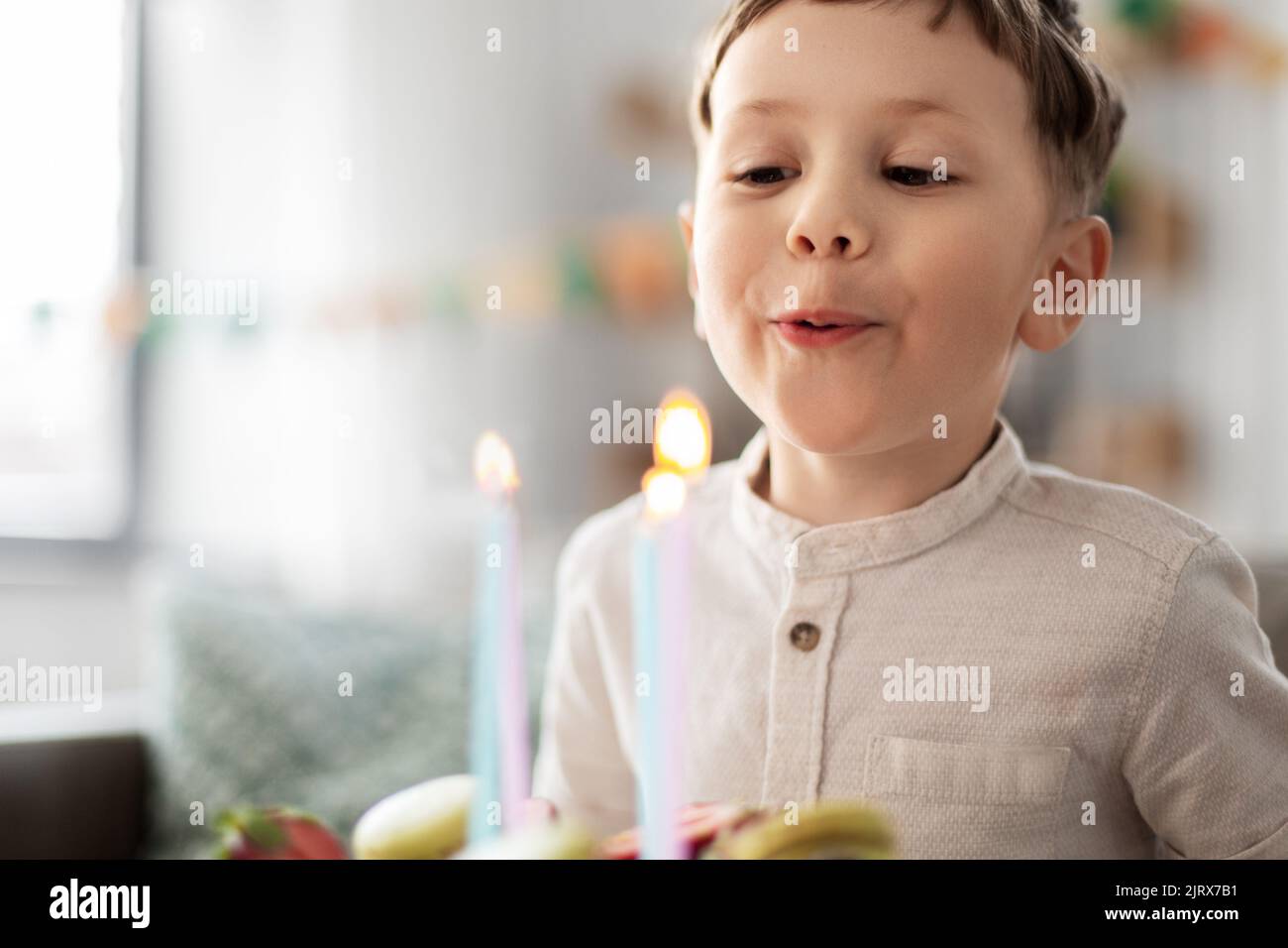 happy little boy blowing candles on birthday cake Stock Photo Alamy
