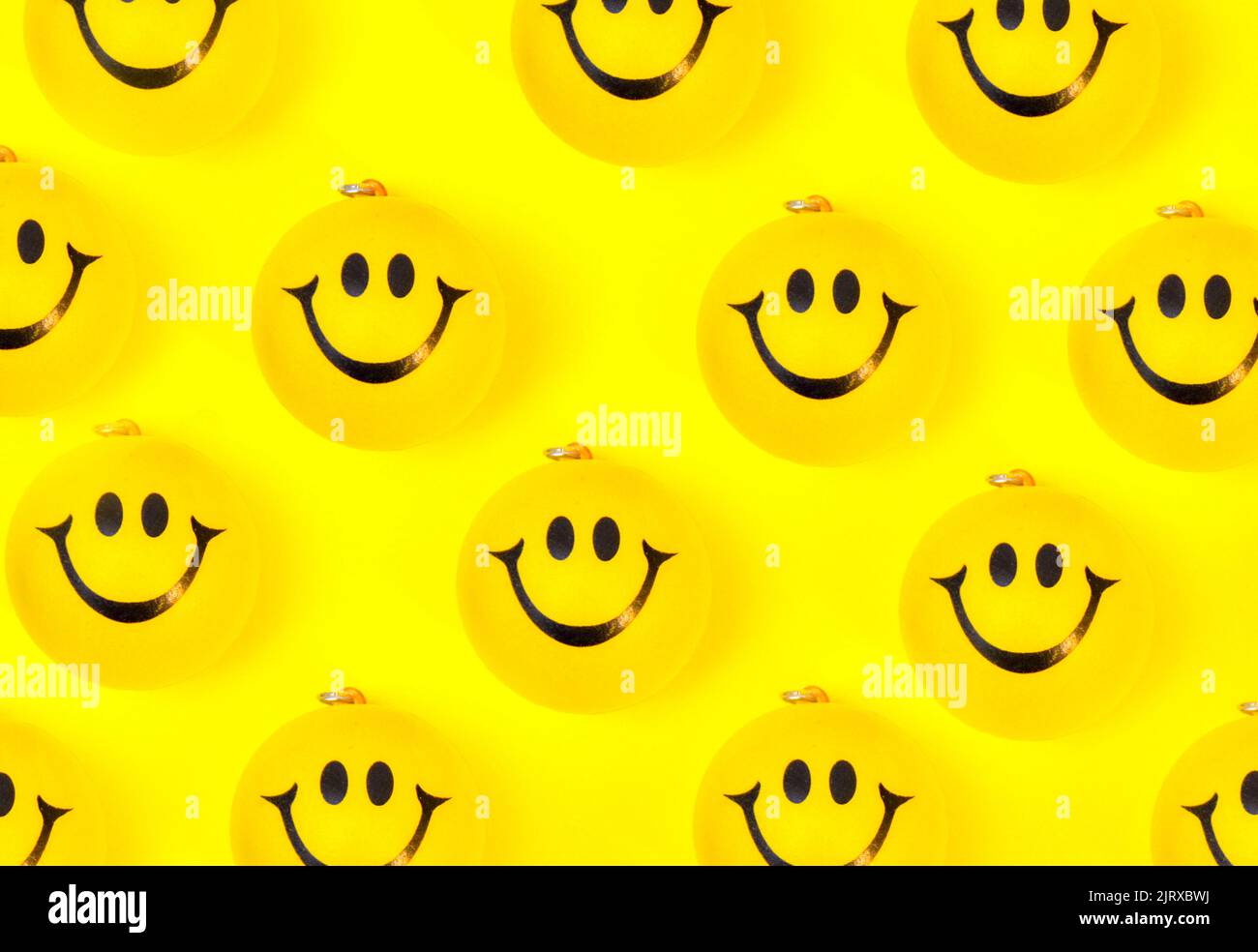 Photo of many yellow smiley faces on yellow background Stock Photo