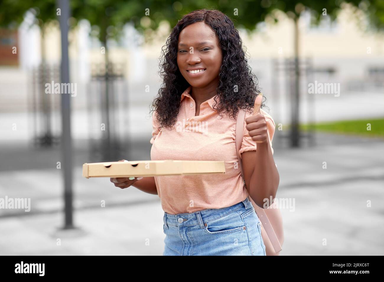 african student girl with pizza showing thumbs up Stock Photo - Alamy