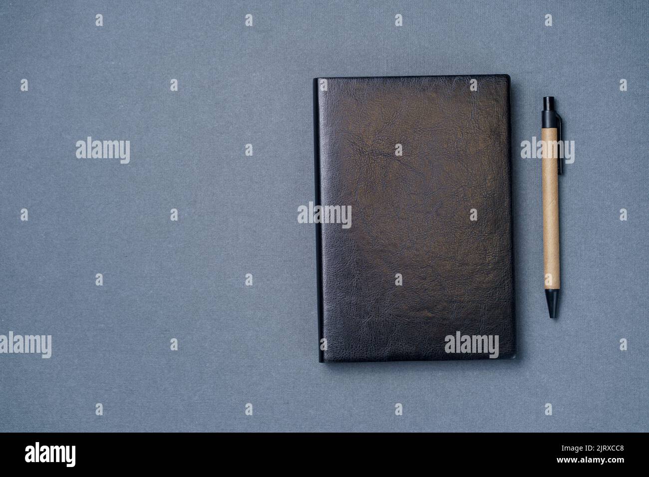 Black leather notebook on a paper gray background, notepad mock up, top