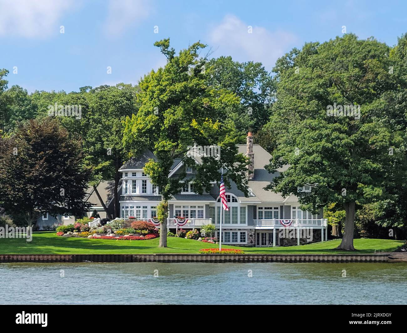 Large estate on a lake with seawall and American flag Stock Photo Alamy