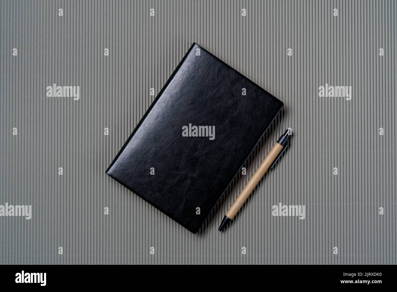 Black leather notebook on a paper gray background, notepad mock up, top