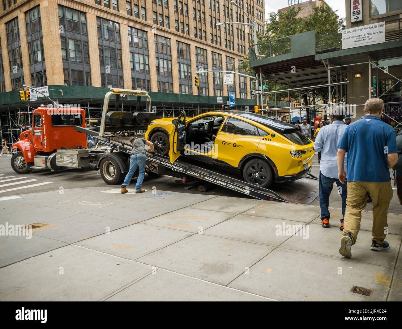A tow truck prepares to remove a disabled Ford Mustang Mach-E EV taxi in Chelsea in New York on Sunday, August 21, 2022. In July Ford delivered 4,970 EV Mustangs outselling the gasoline powered Mustang. (© Richard B. Levine) Stock Photo