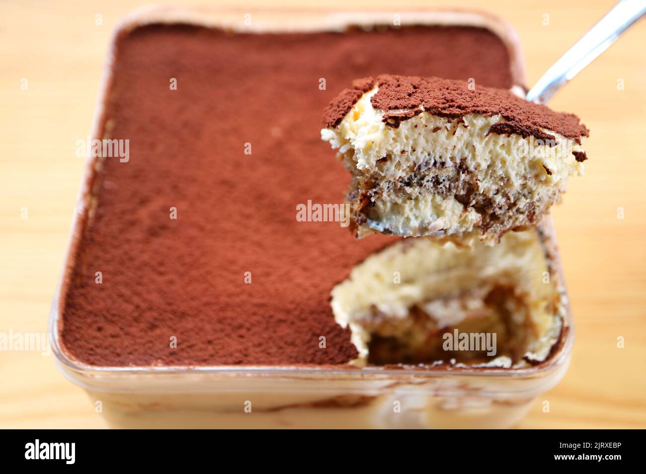 Closeup of a Spoon Scooping Delectable Tiramisu Stock Photo