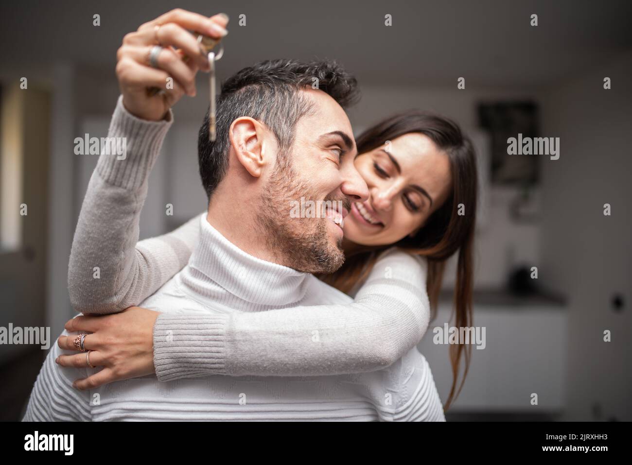 Happy couple showing the keys of their new house Stock Photo - Alamy