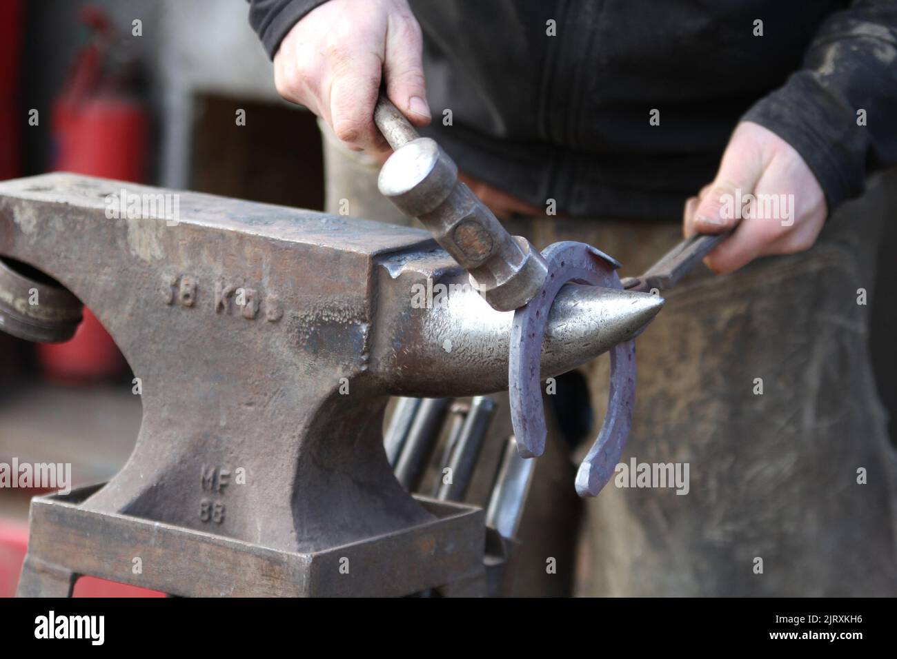 Farrier working a horseshoe on an anvil ready to shoe a horse