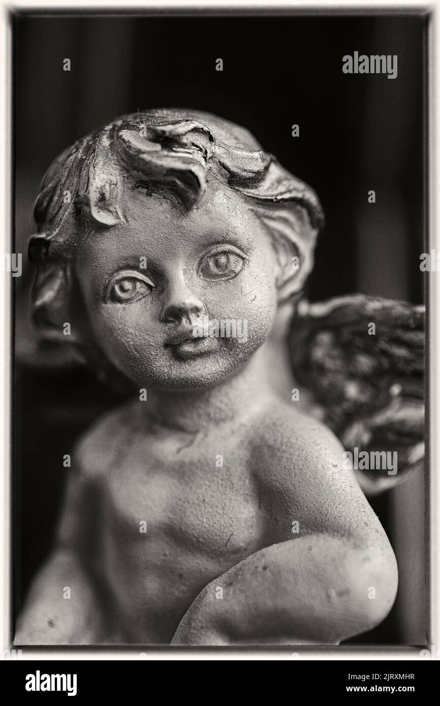 A grayscale shot of a child statue on blurred background Stock Photo