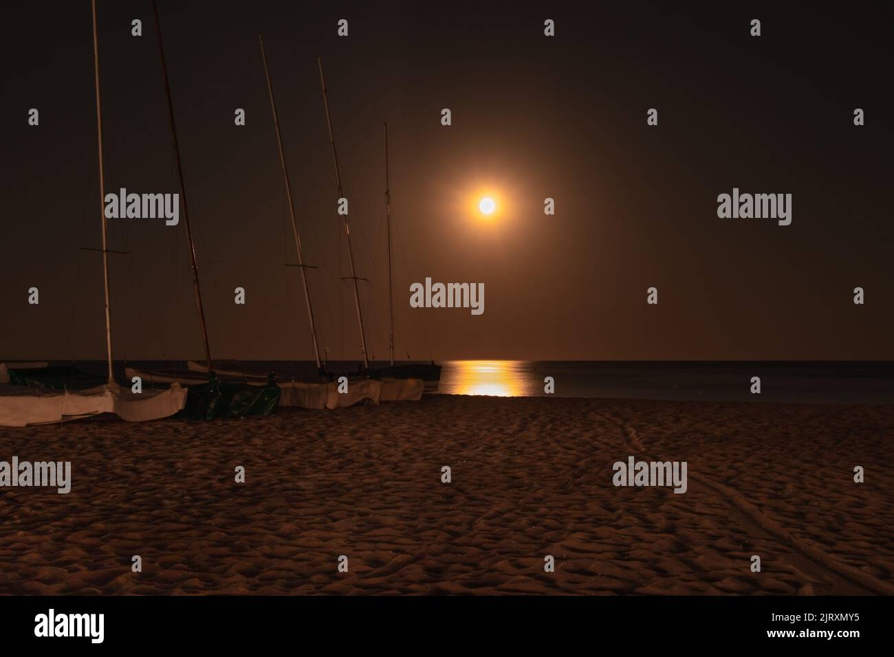 Yachts on the beach at night in Coma Ruga, Spain Stock Photo - Alamy