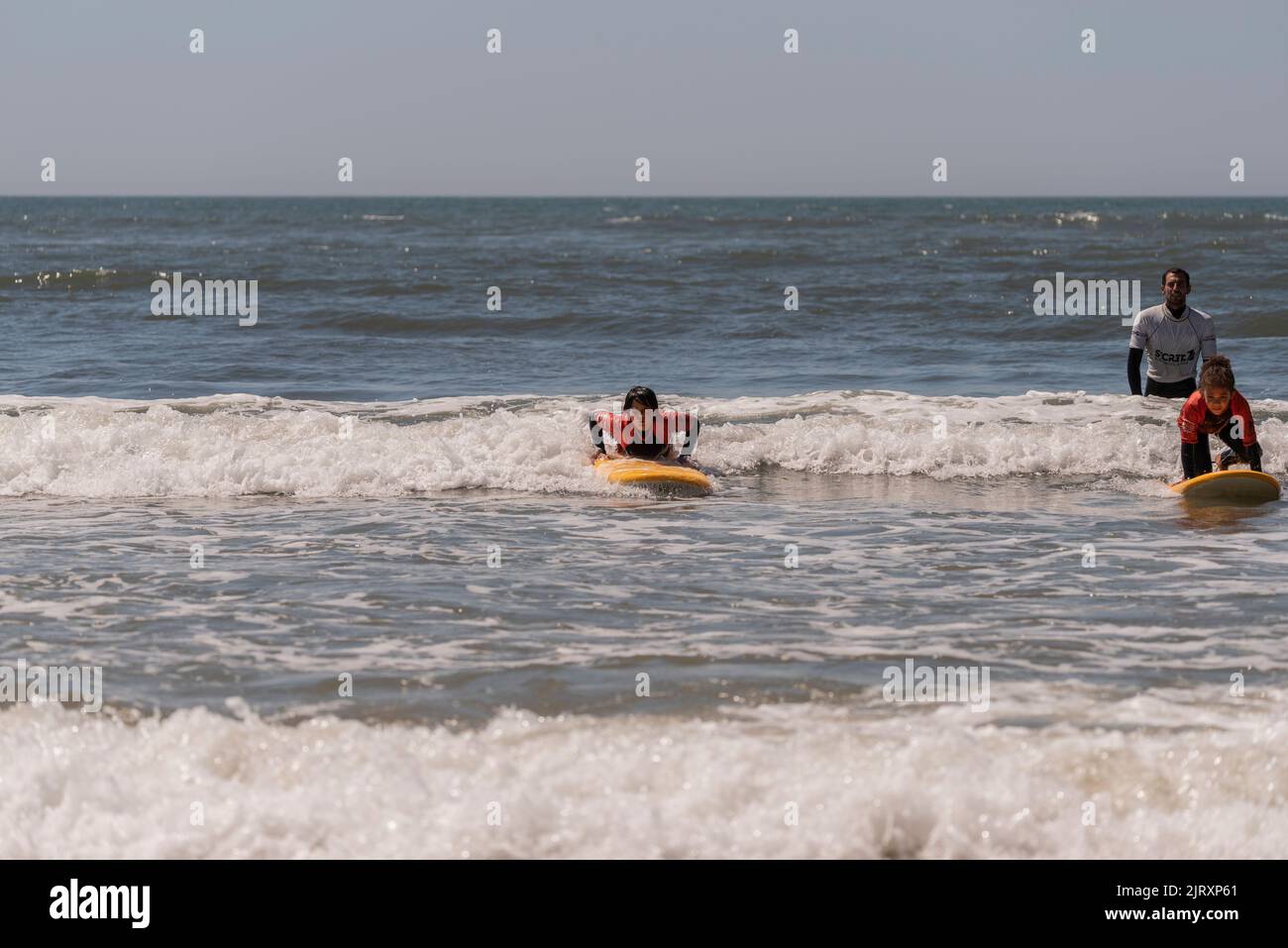 Aveiro, Portugal. august 19 - 2022: Surf lessons for children first class in the beach Take the first wave. Stock Photo