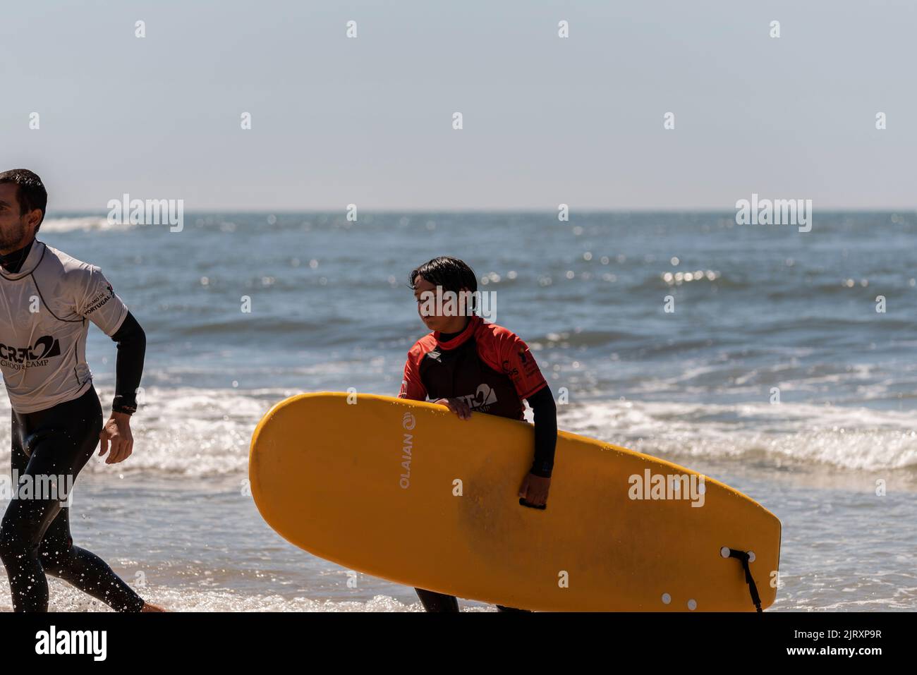 Aveiro, Portugal. august 19 - 2022: Surf lessons for children first class in the beach. children go out the sea Stock Photo