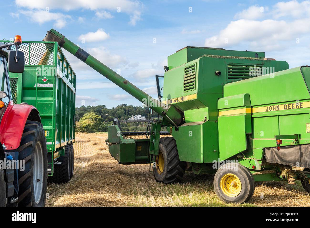 Ballynacarriga, West Cork, Ireland. 26th Aug, 2022. On a sunny day, Denis Duggan of Duggan Agri Contractors harvests barley using a 1992 John Deere 1177 Combine Harvester averaging 3.3/t per acre at a moisture content of 17%. Credit: AG News/Alamy Live News Stock Photo