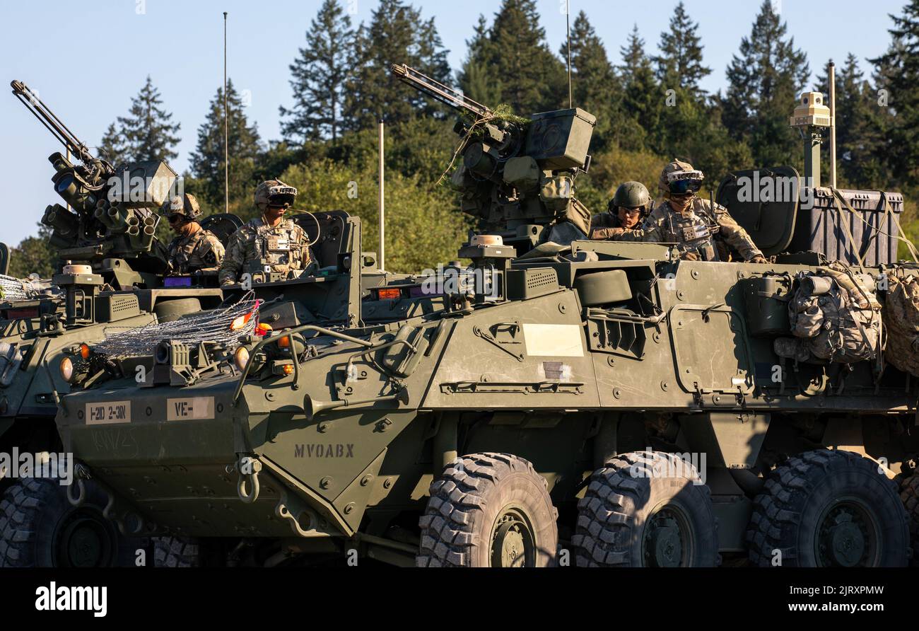 Soldiers from 3rd Platoon, Blackhorse Company, 2-3 Infantry Regiment, 1-2 Stryker Brigade Combat Team wear upgraded Integrated Visual Augmentation System goggles while sitting atop Stryker armored vehicles preparing for a movement-to-contact urban raid exercise on Joint Base Lewis-McChord, Wash., August 24, 2022. The exercise was part of a two-day demonstration event hosted by the Program Executive Office of Ground Combat Systems with the aim of integrating soldier feedback into the development of new military combat technology. (U.S. Army photo by Spc. Chandler Coats, 5th Mobile Public Affair Stock Photo