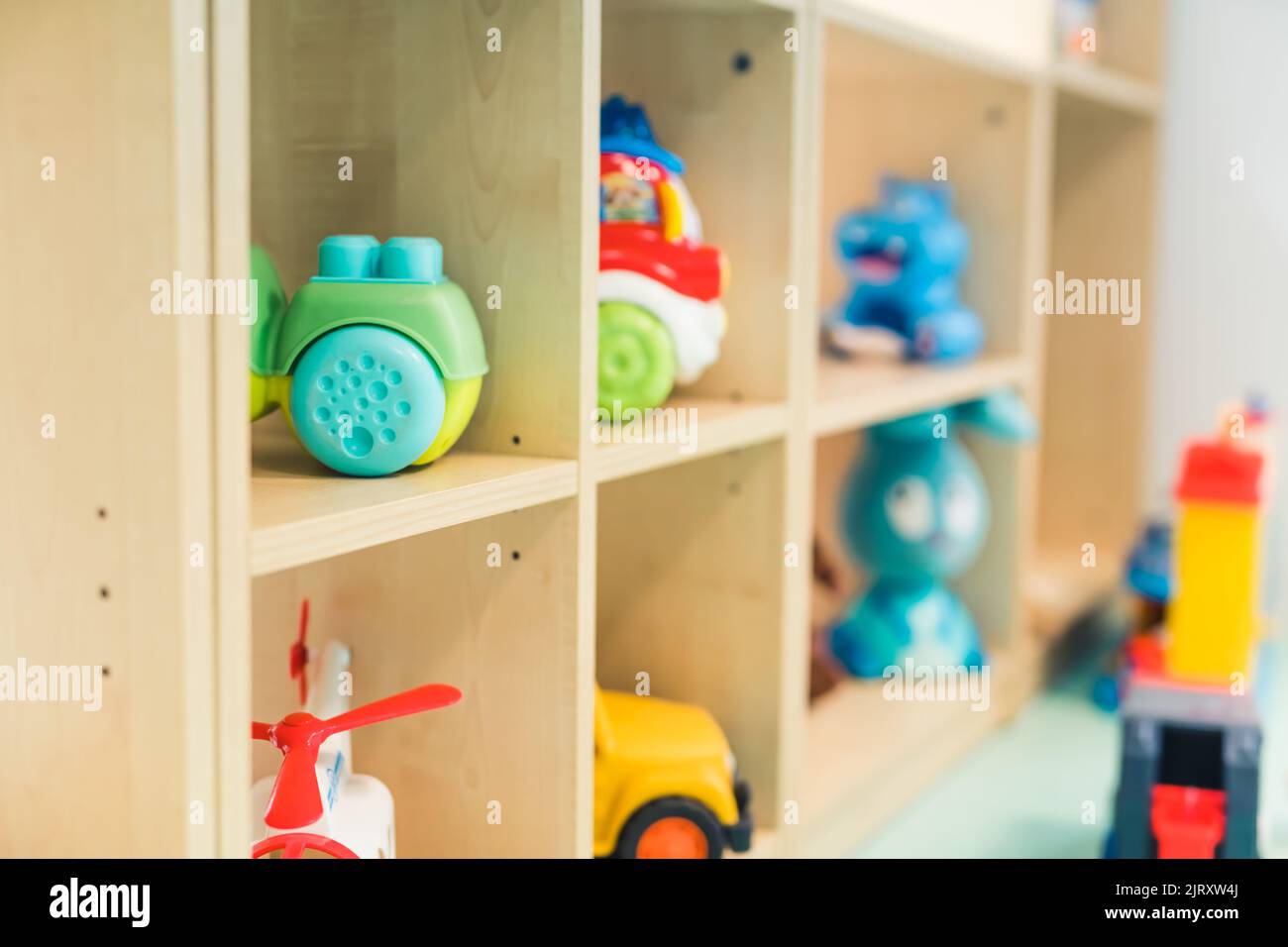 Different kinds of colorful plastic and plush toys on the shelves in