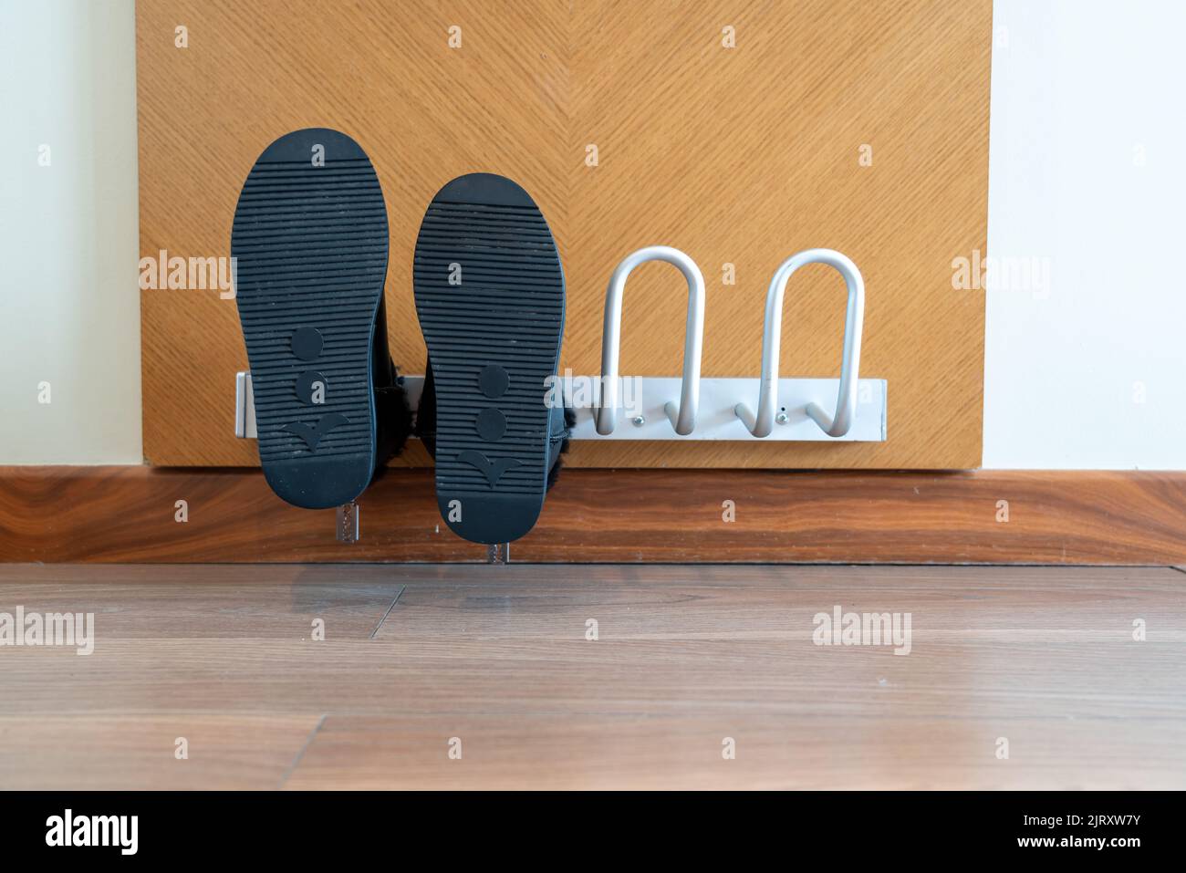 Wallmounted electric dryer with shoes put on it in a hotel room Stock