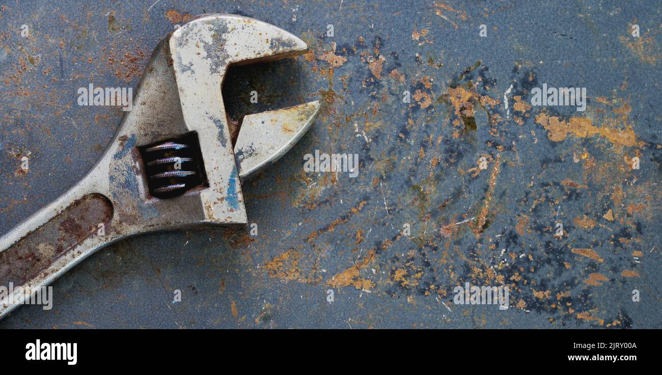 Adjustable wrench on distressed rusty metal with copy space Stock Photo