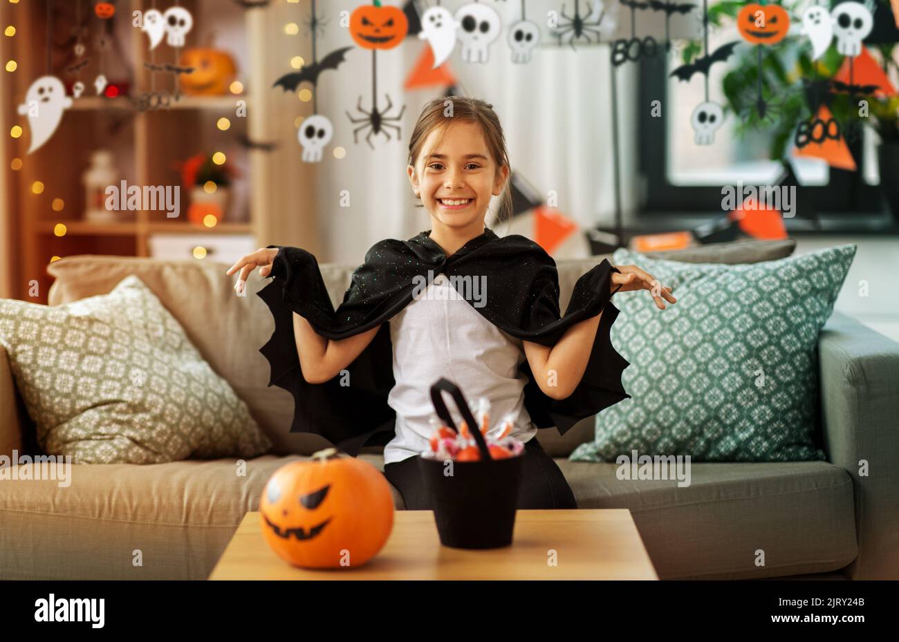 girl in halloween costume with bat cape at home Stock Photo