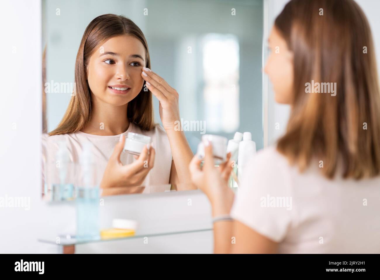 teenage girl with moisturizer at bathroom Stock Photo Alamy
