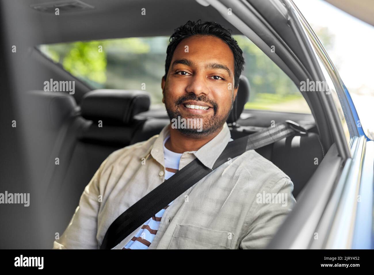 smiling indian male passenger in taxi car Stock Photo