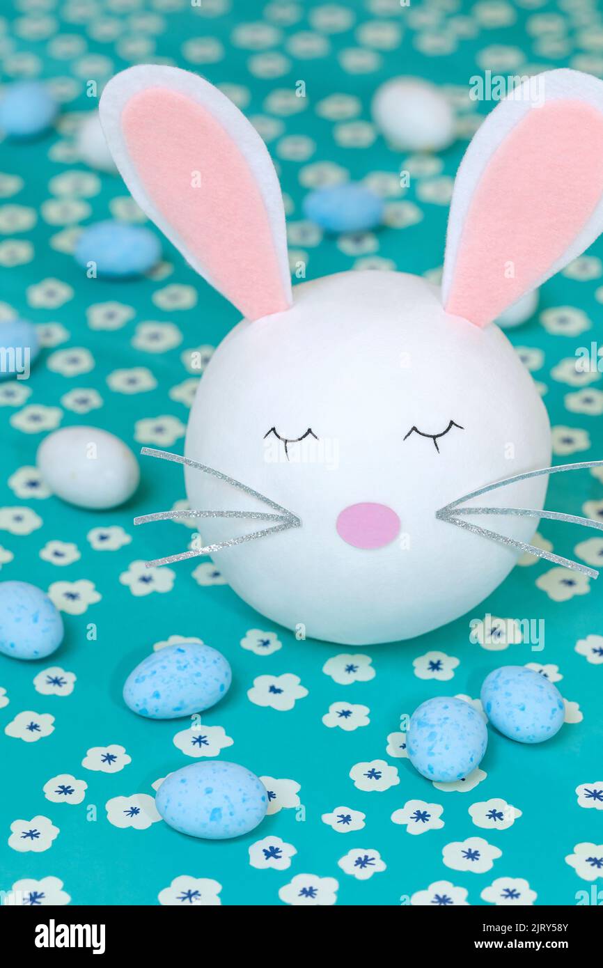 Cute bunny head with blue and white chocolate eggs Stock Photo