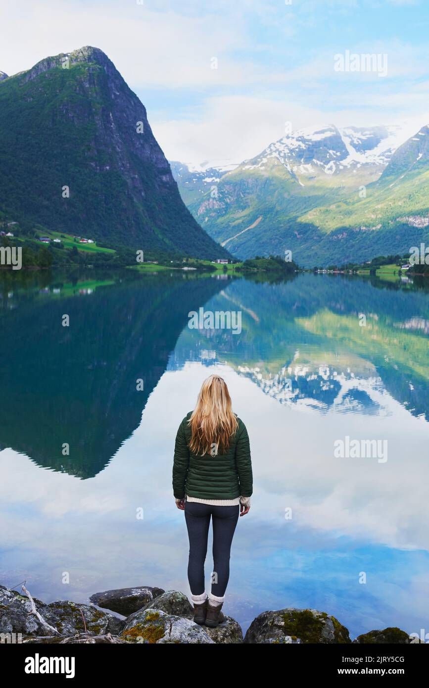 Adventure woman enjoying view of majestic mountain lake explore travel discover beautiful earth Stock Photo