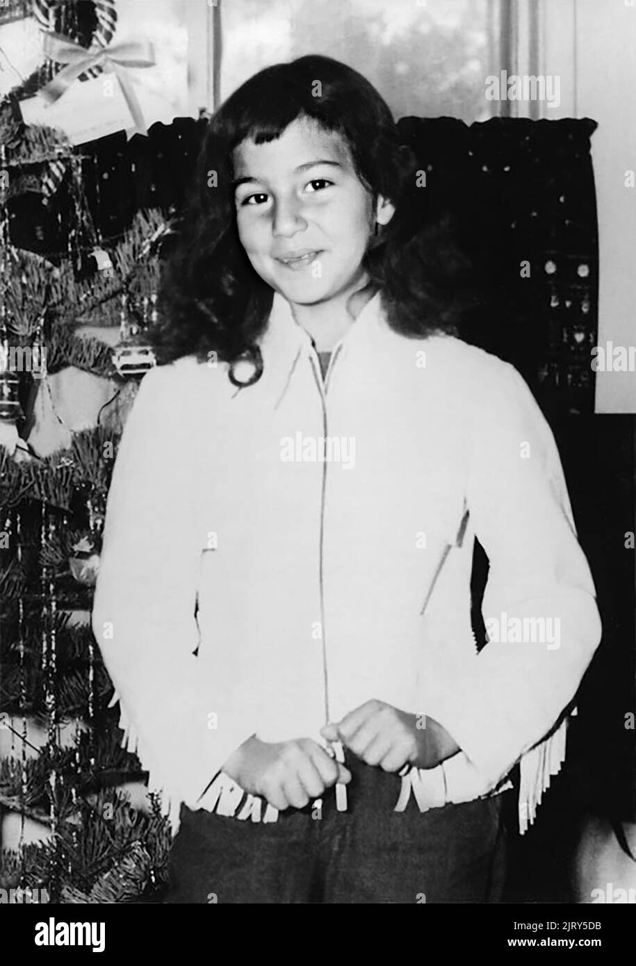 1956 , december , USA : The celebrated american Pop singer and actress  CHER ( Cherilyn Sarkisian LaPierre , born 20 may 1946 ) when was a young girl aged 10 at Xmas  . Unknown photographer. - HISTORY - FOTO STORICHE - personalità da giovane giovani - ragazza - personality personalities when was young girl - INFANZIA - CHILDHOOD - POP MUSIC - MUSICA - cantante - BAMBINI - BAMBINA - CHILD - CHILDREN - BAMBINO - CHILDHOOD - INFANZIA - smile - sorriso - ALBERO DI NATALE - Christmas Tree --- ARCHIVIO GBB Stock Photo