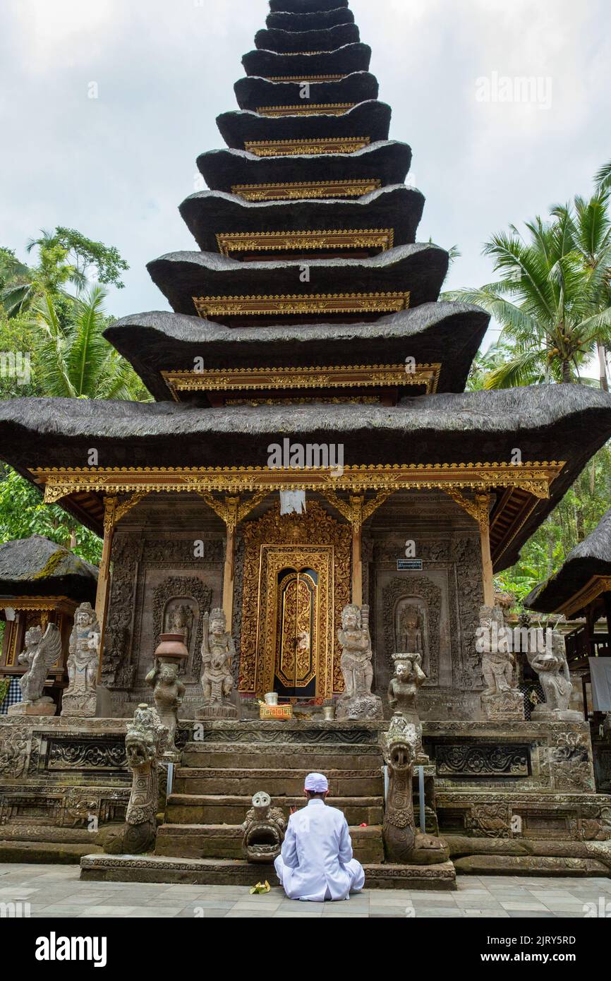 Hindu priest praying inside Pura Kehen, Kintamani, Bali Stock Photo