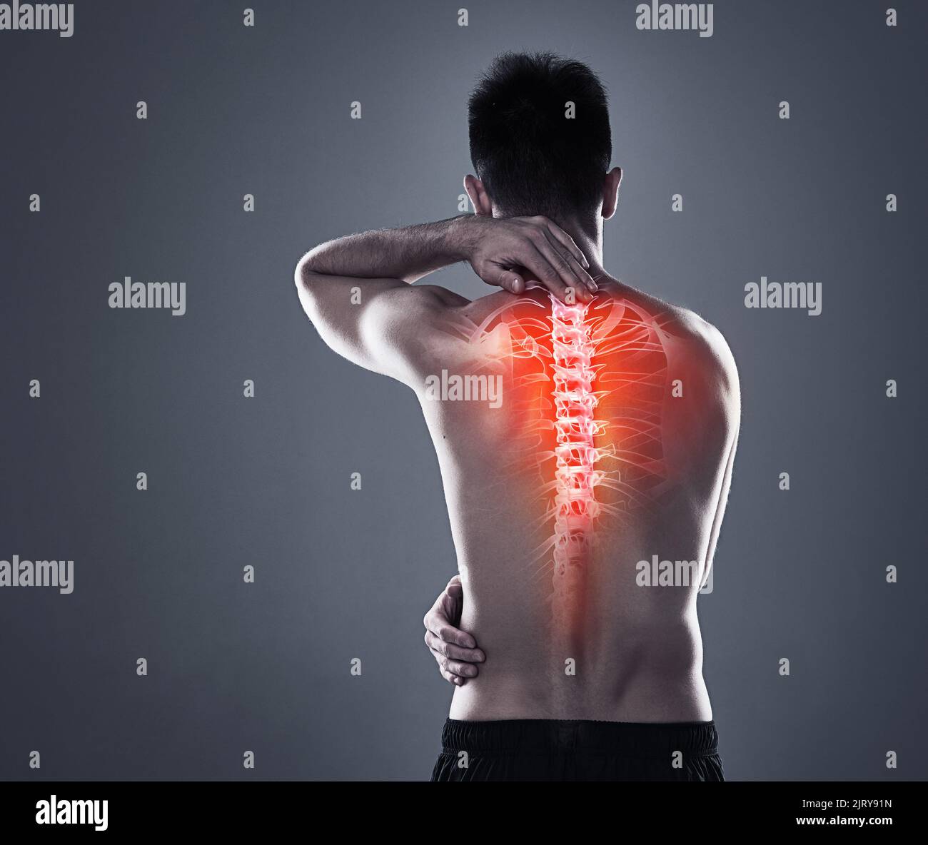 Back injuries are no joke. Rearview shot of a young man in the studio ...