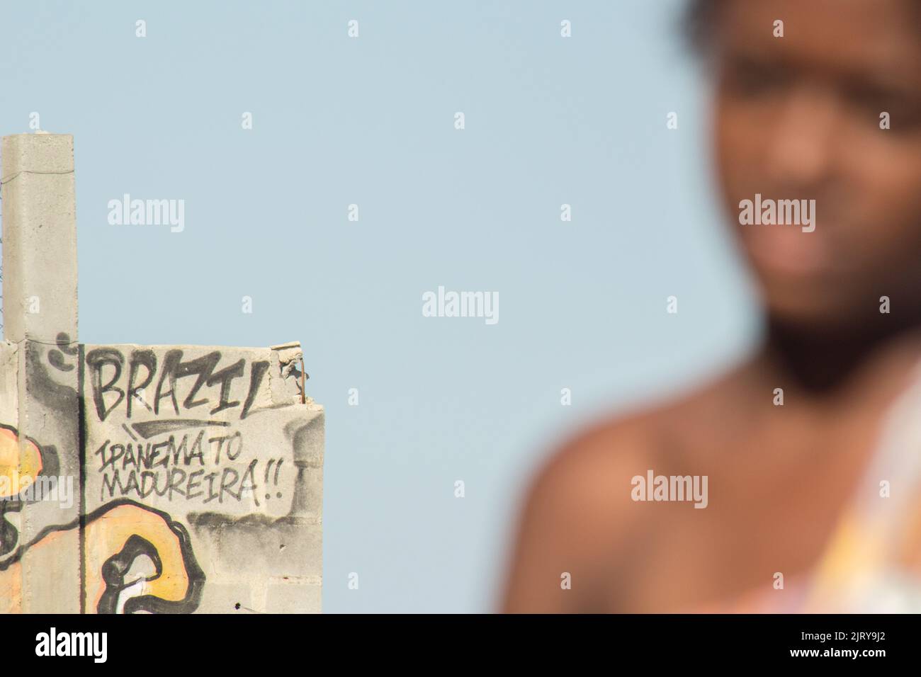 concrete wall with writing (Brazil Ipanema to madureira !!) with an unfocused black woman. Stock Photo