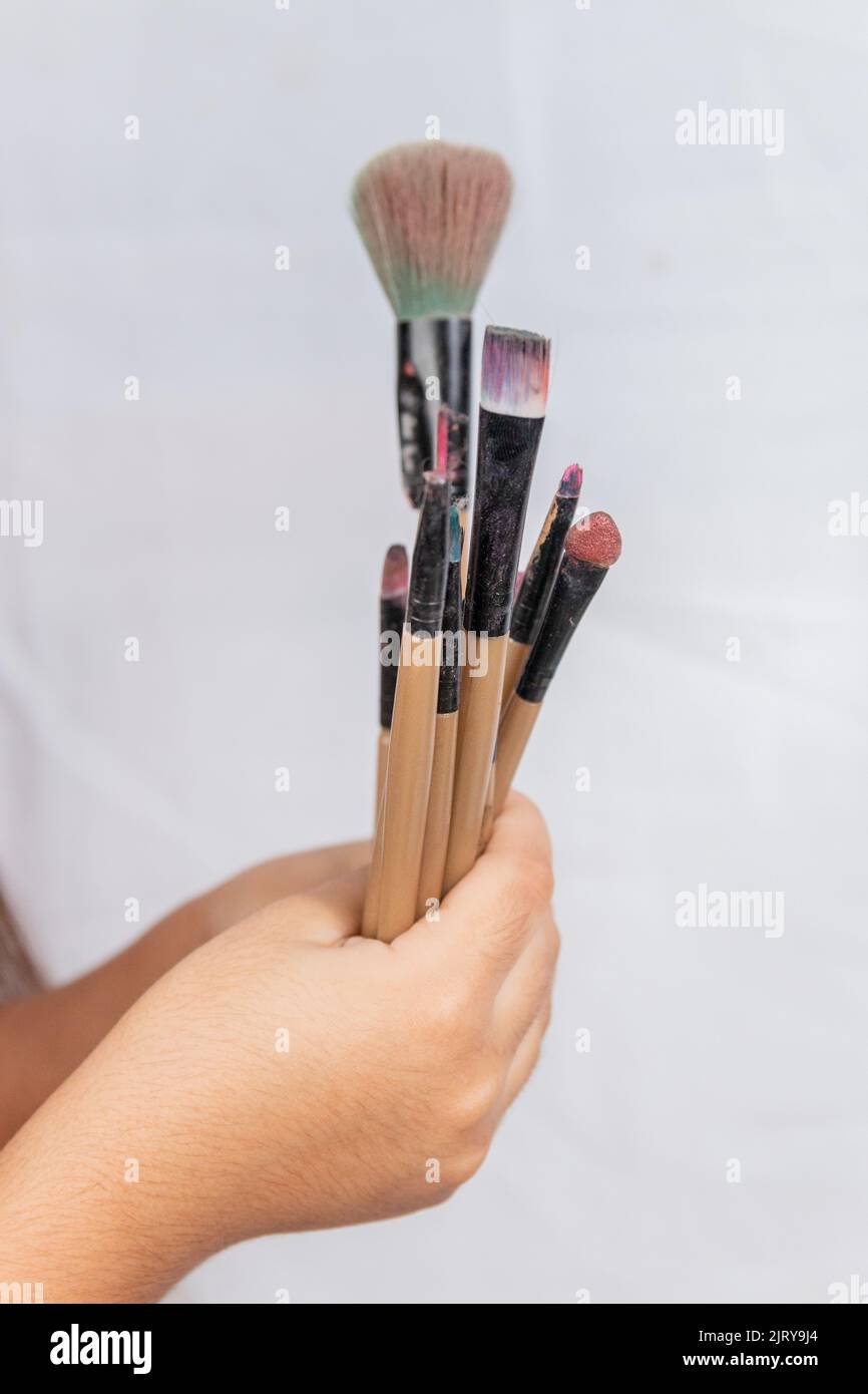 child with makeup brushes with white background in rio de janeiro Brazil Stock Photo