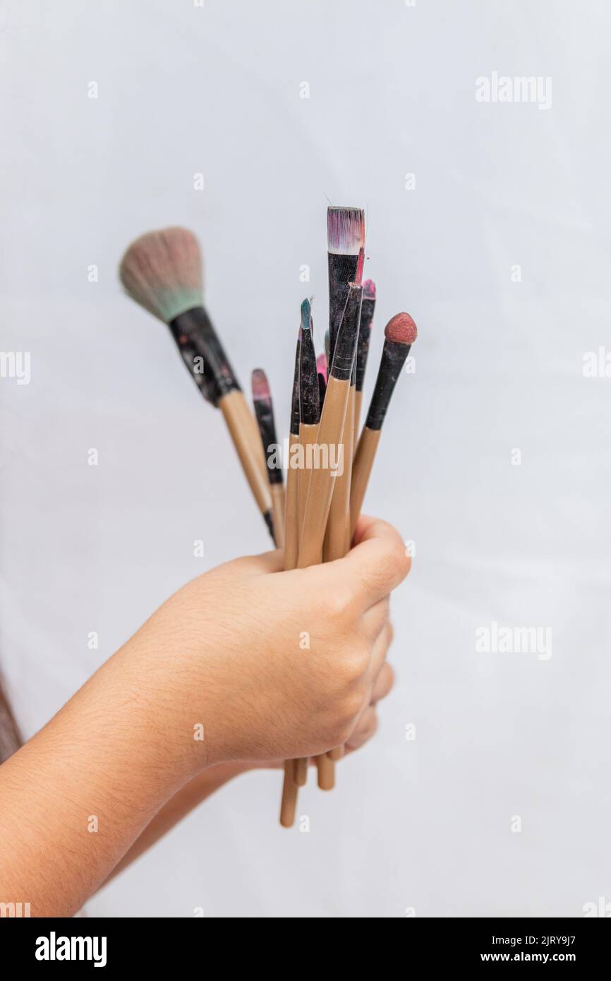 child's hand holding makeup brushes in Rio de Janeiro. Stock Photo