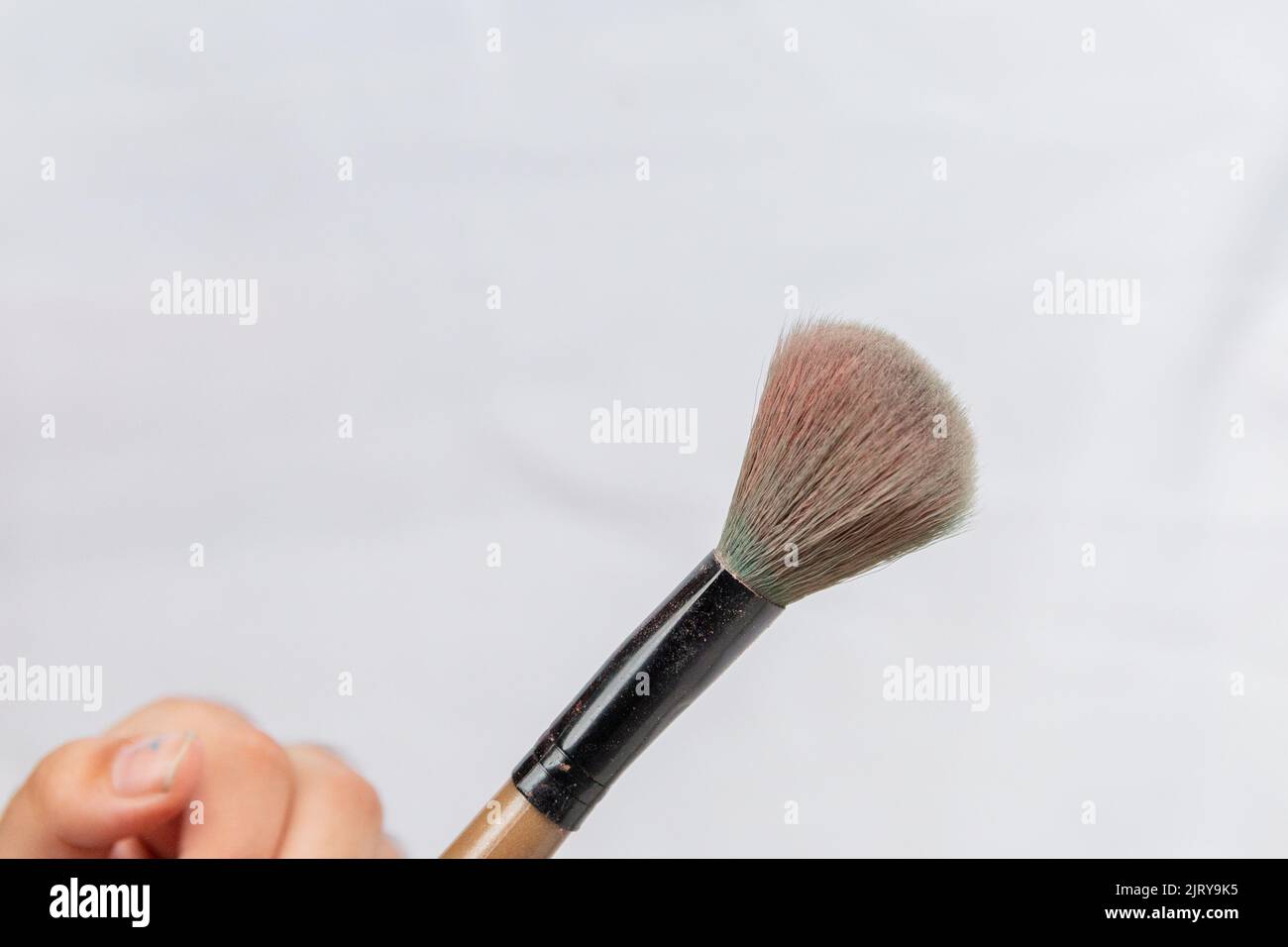 child's hand holding makeup brushes in Rio de Janeiro. Stock Photo