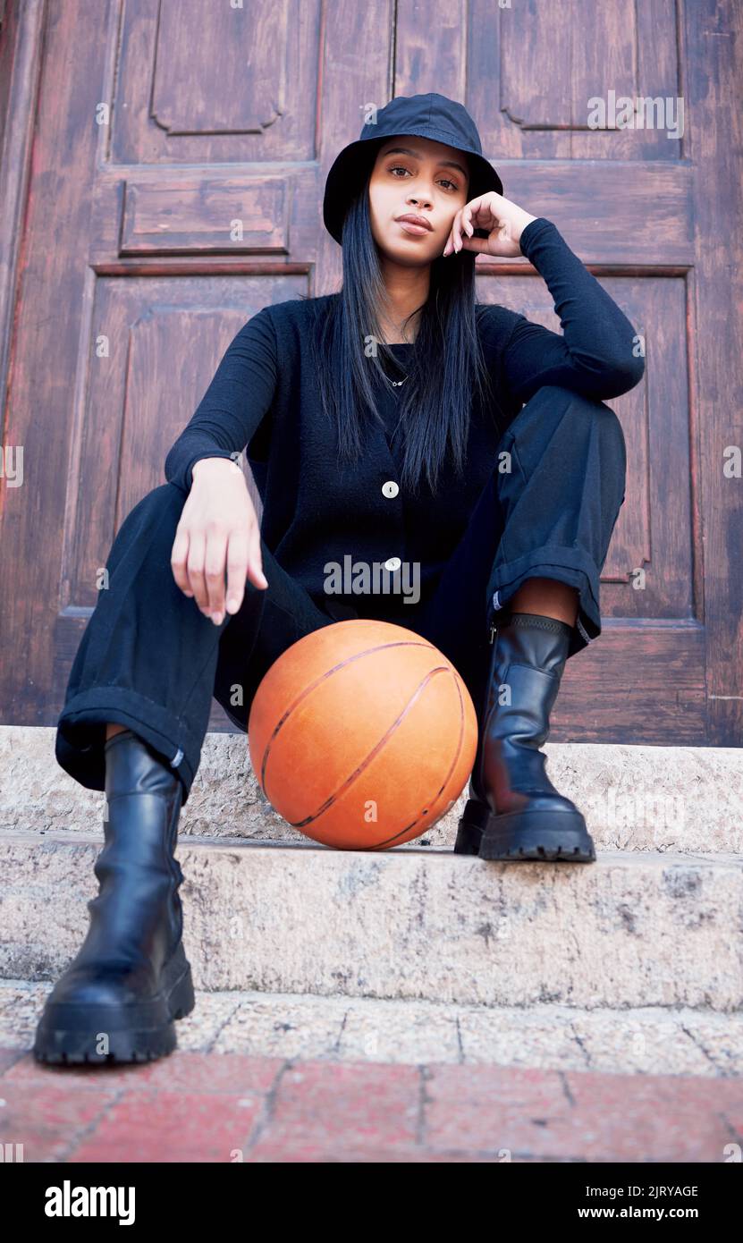Basketball, fashion and model influencer of a woman posing on steps in an urban city with fashionable style. Female portrait of trendy, stylish and Stock Photo