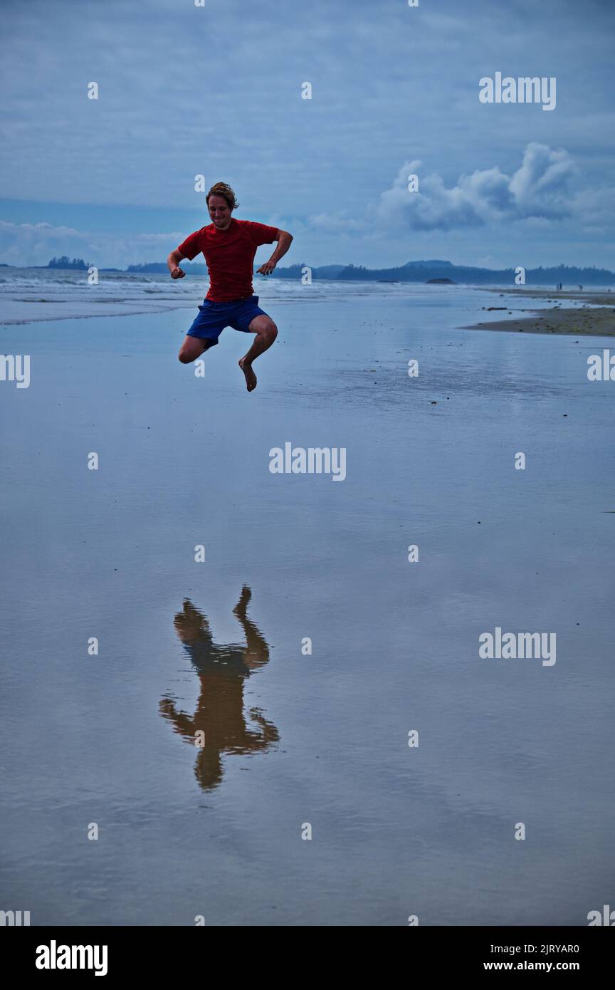 Mature man jumping on the beach and having fun Stock Photo
