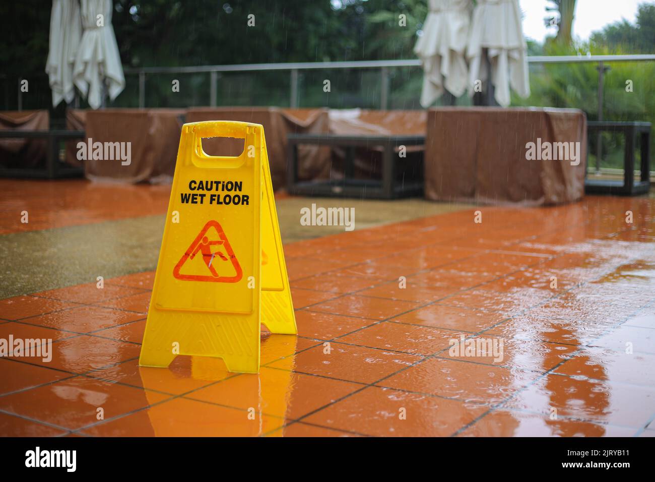 Caution wet floor yellow sign warning while it raining outside. Safety