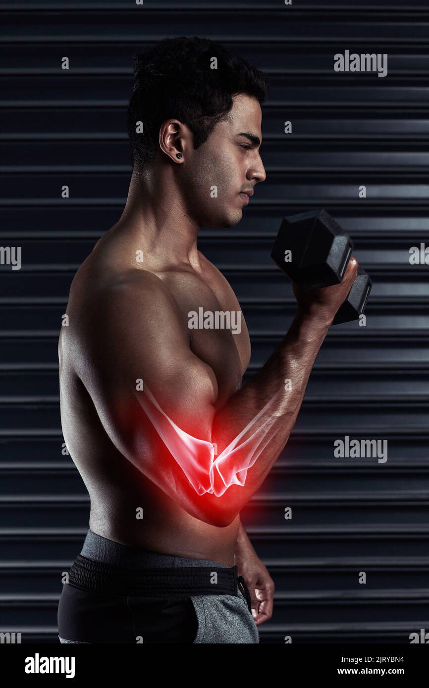 Feeling the pressure of the weight in his elbow. an athletic young man working out with a dumbbell. Stock Photo