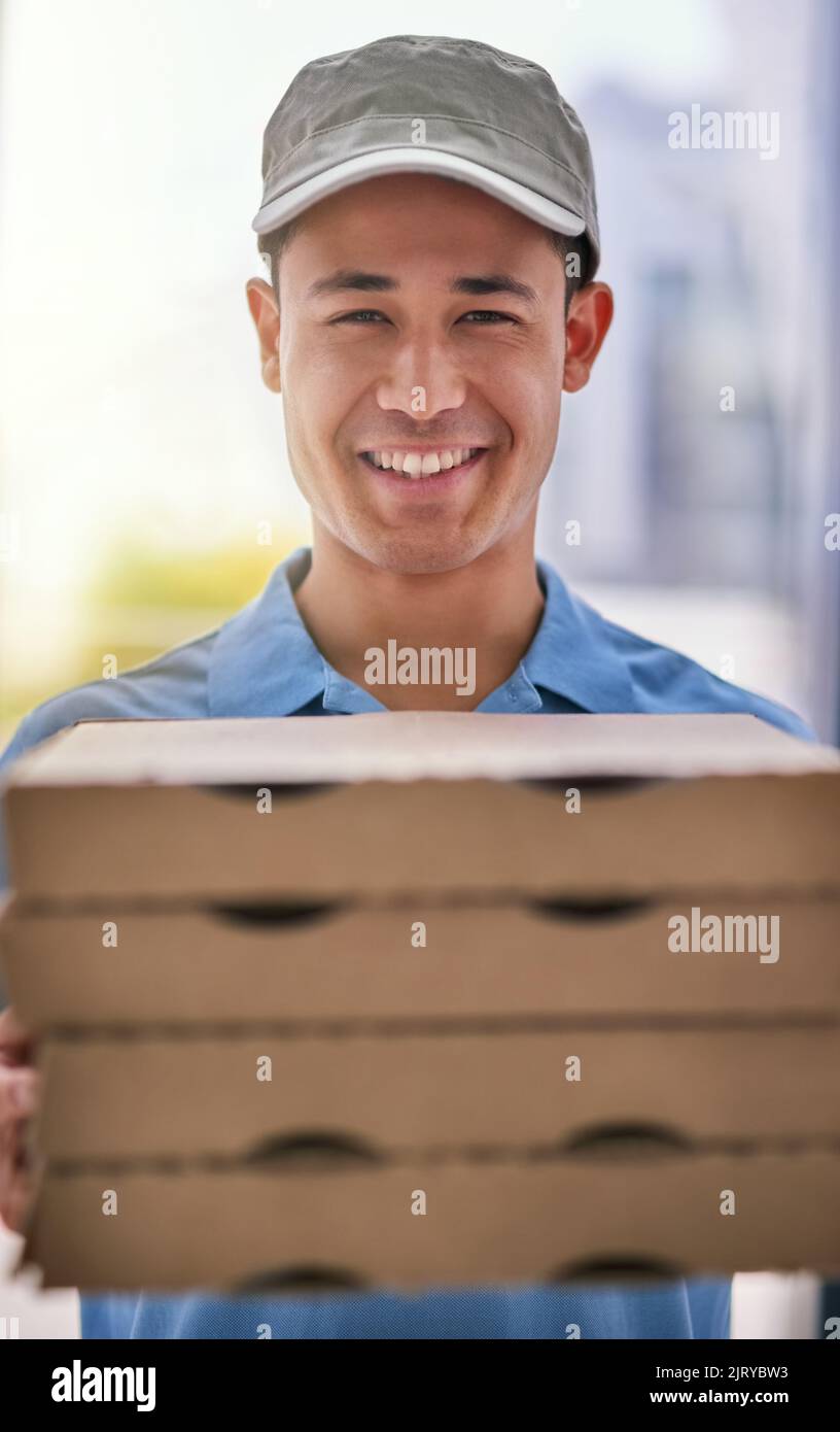 From our ovens to your door. Portrait of a happy deliveryman holding a