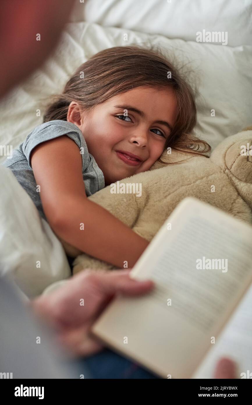 She cant sleep without her favourite story first. a little girl lying