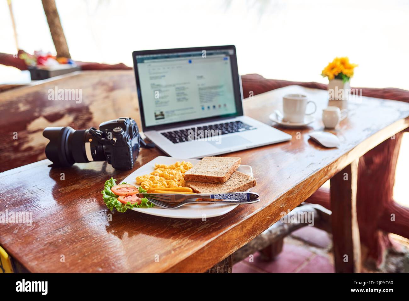 Blogging at breakfast. a laptop and freshly made breakfast on a table outside. Stock Photo